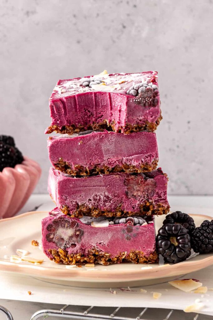 Blackberry cobbler bars stacked with bite showing creamy filling