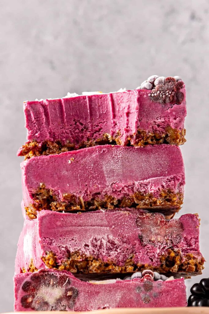 Blackberry cobbler bars stacked with bite showing creamy filling