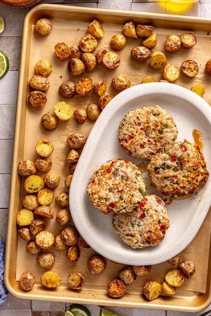 Healthy jalapeño burgers and roasted potatoes on a sheet pan, ready to serve