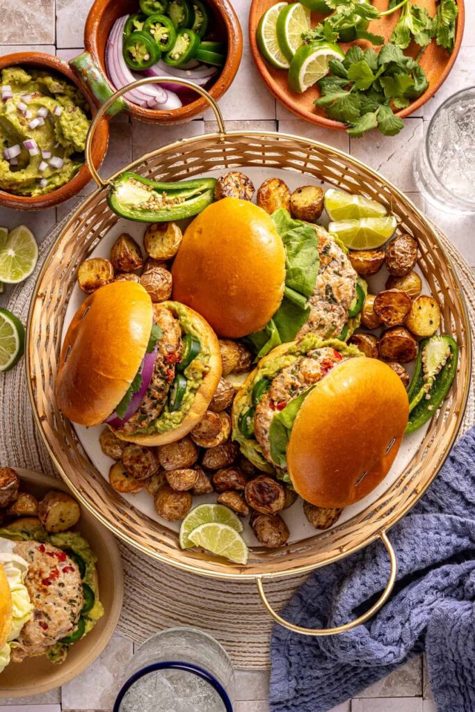 overhead shot of homemade jalapeño burgers and roasted potatoes on a set table