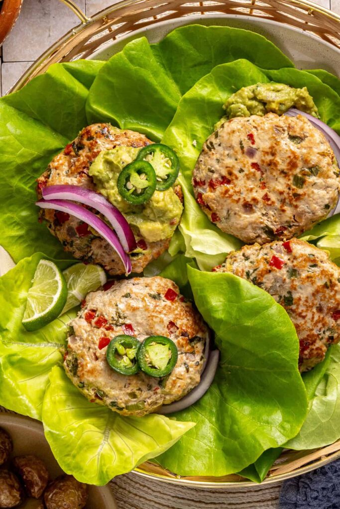 overhead shot of healthy jalapeño burgers served in lettuce cups with garnishes