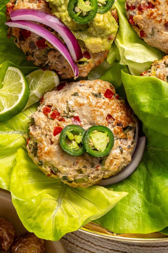 Jalapeño burgers plated with fresh toppings and sides