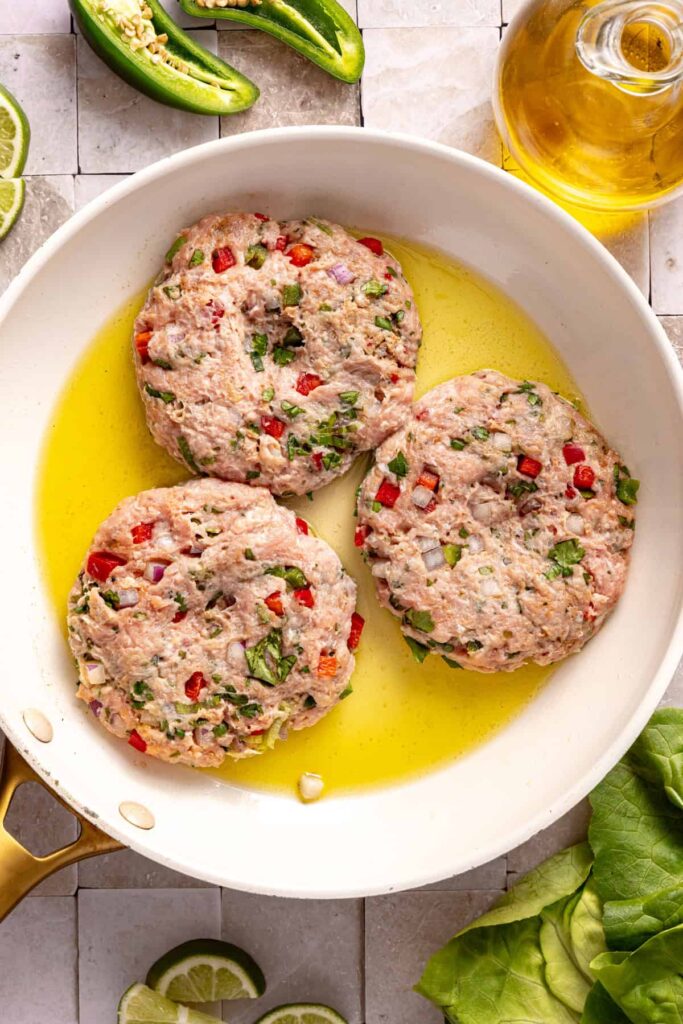 Cooking jalapeño burgers in skillet on stovetop