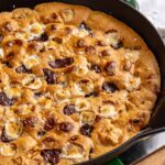 Gluten-free s'mores cookie skillet baked in a cast-iron skillet with melted marshmallows, chocolate and graham cracker pieces