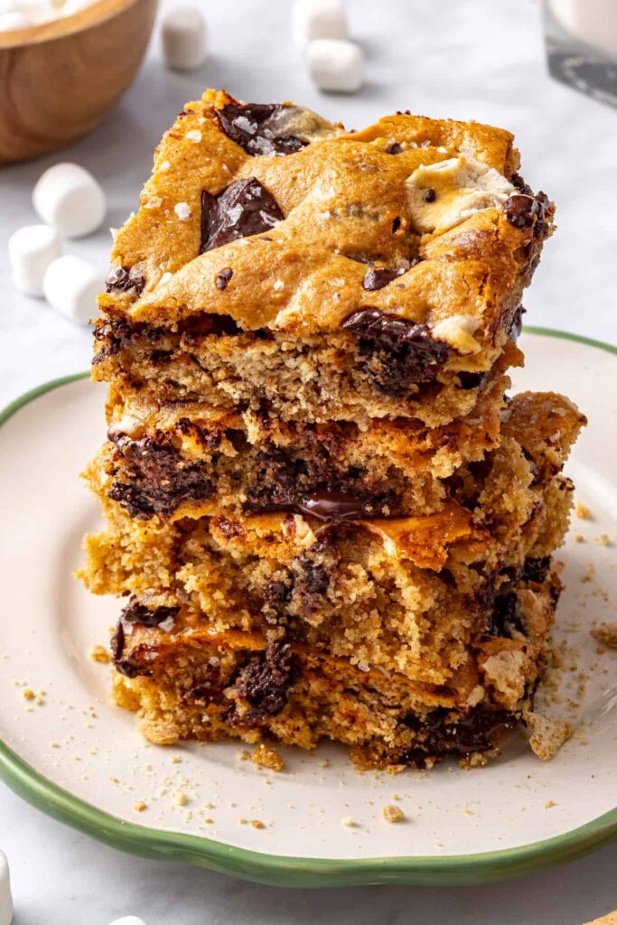 Three s'mores cookie skillet bars stacked on a plate