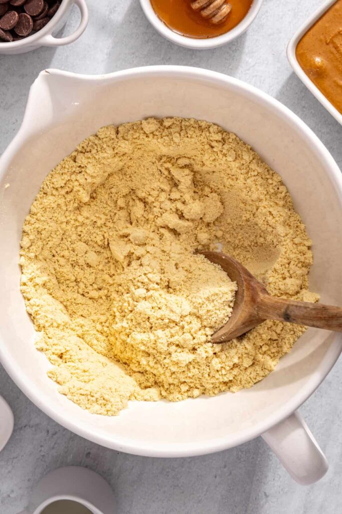 Whisking almond flour and protein powder for peanut butter protein bars