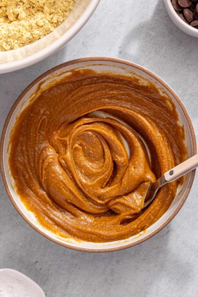 Mixing peanut butter, honey, and almond milk until smooth