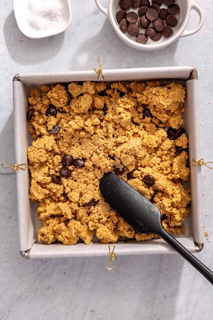 Smoothing peanut butter protein bars mixture with spatula