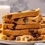 Homemade dairy-free, gluten-free peanut butter protein bars stacked on white plate