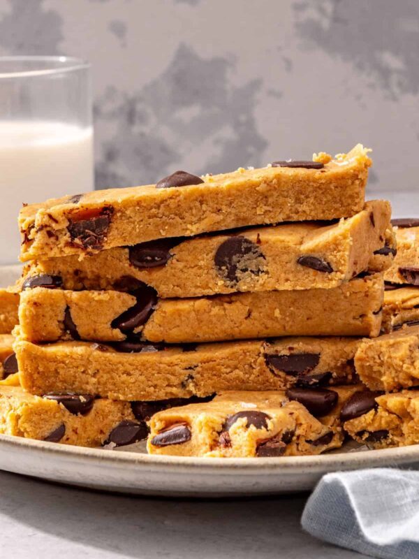 Homemade dairy-free, gluten-free peanut butter protein bars stacked on white plate