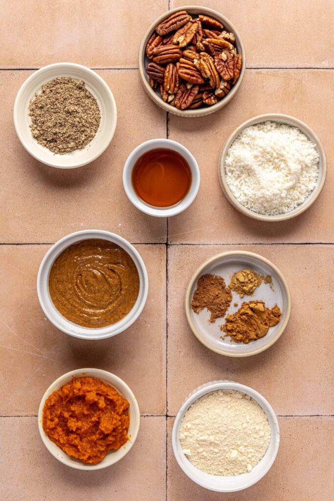 Ingredients for pumpkin protein balls including pumpkin purée, pecans, and almond butter