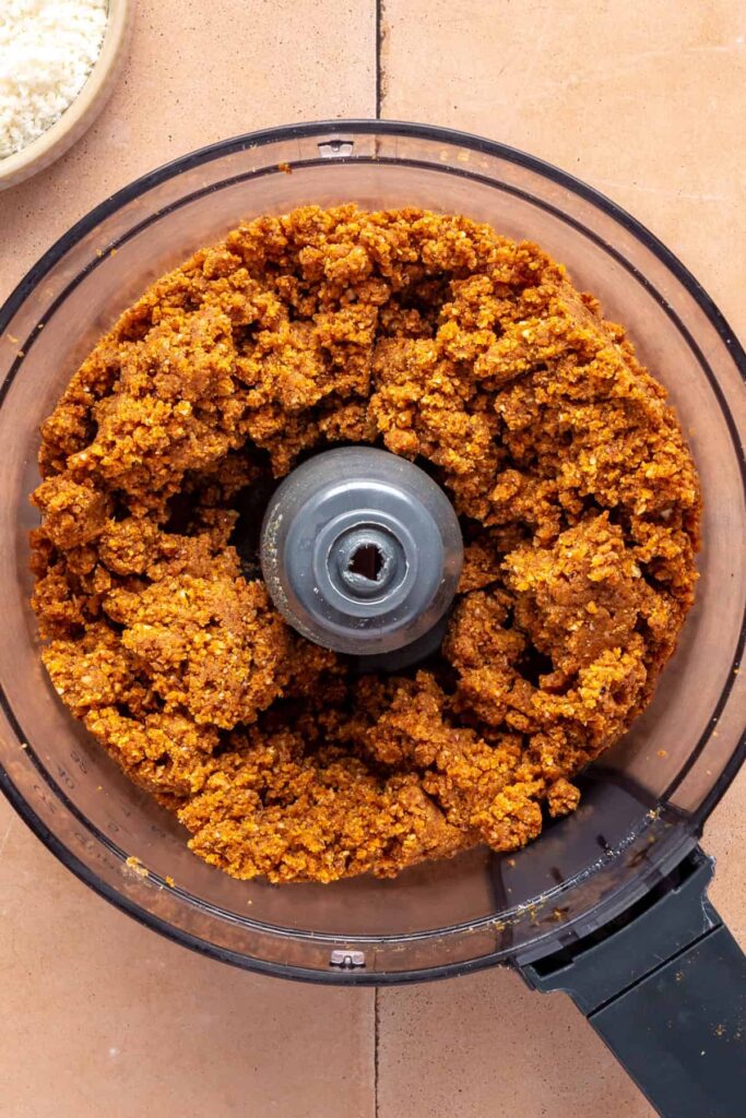 Mixing pumpkin purée, almond butter, and pecans to make pumpkin protein balls