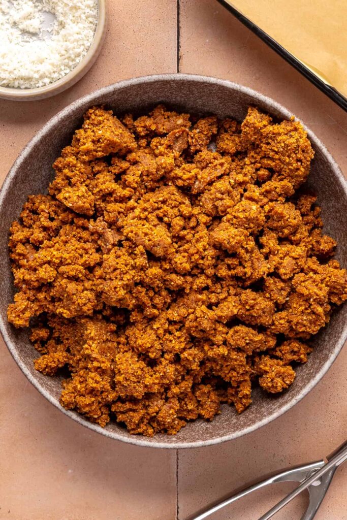 Mixing pumpkin purée, almond butter, and pecans to make pumpkin protein balls