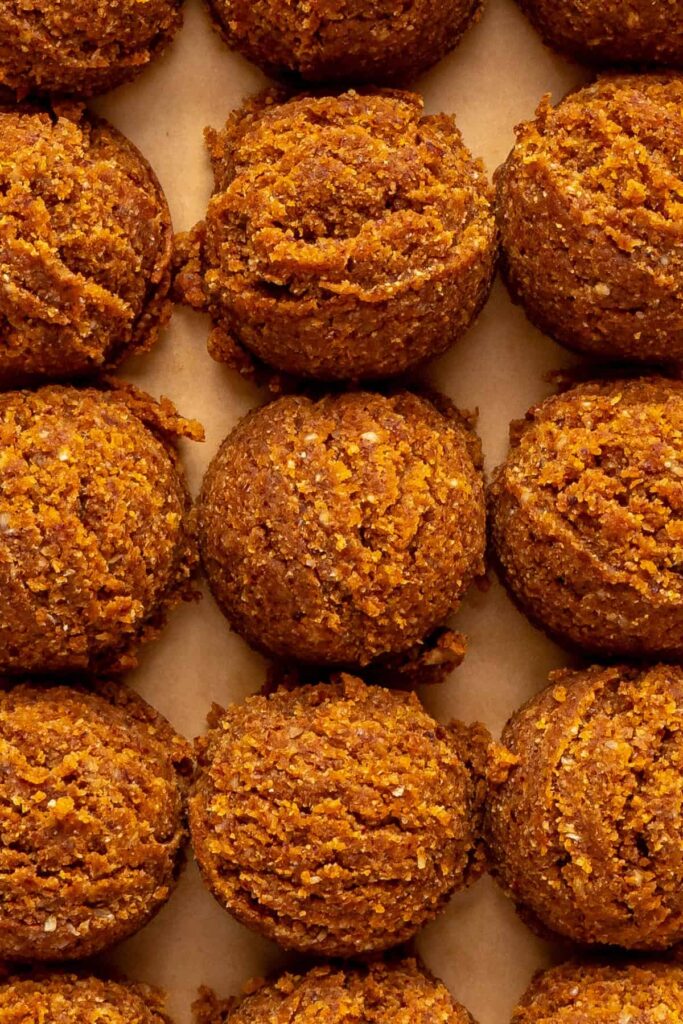 close-up of bite-sized pumpkin protein balls before rolling in shredded coconut topping
