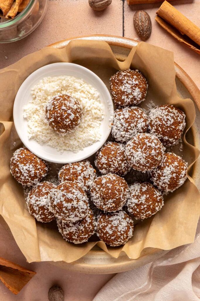 Healthy pumpkin protein balls in a bowl topped with shredded coconut