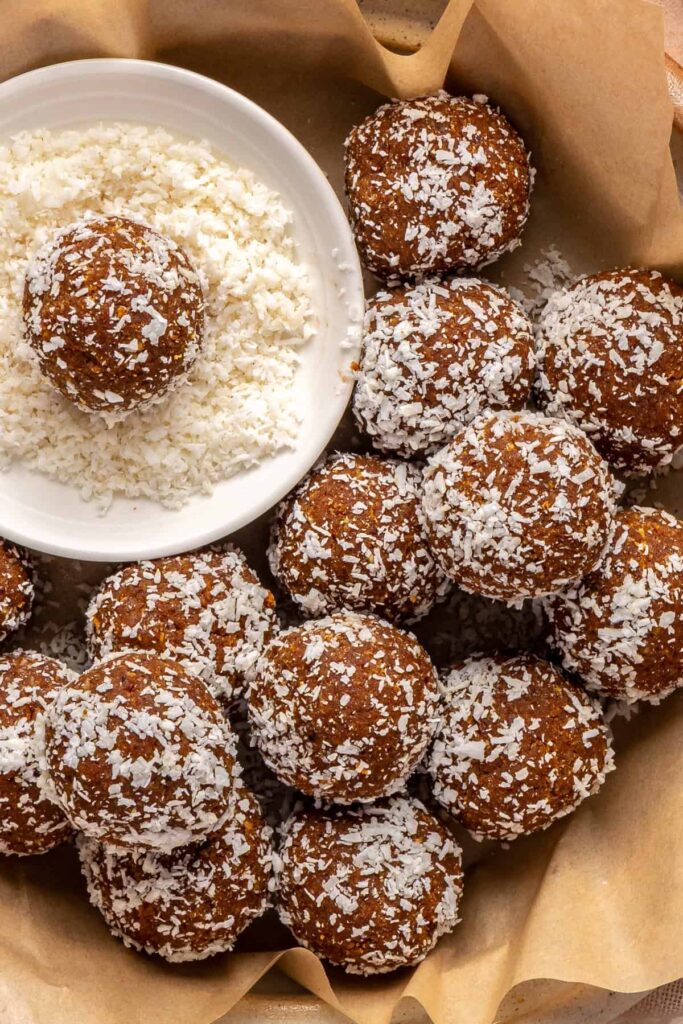 Healthy pumpkin protein balls in a bowl topped with shredded coconut