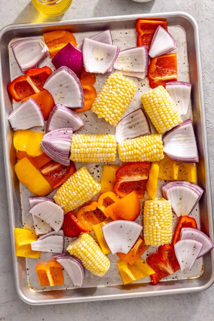 seasoned corn, peppers, and onions, ready to be grilled for a chicken teriyaki recipe