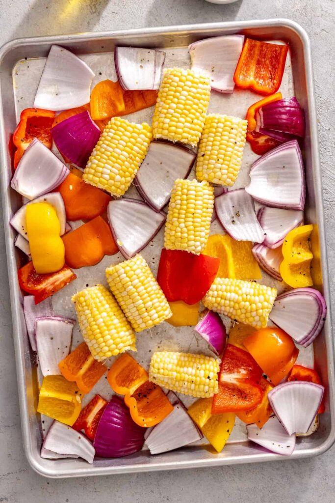 Corn, peppers, and onion prepared for grilled teriyaki chicken dinner