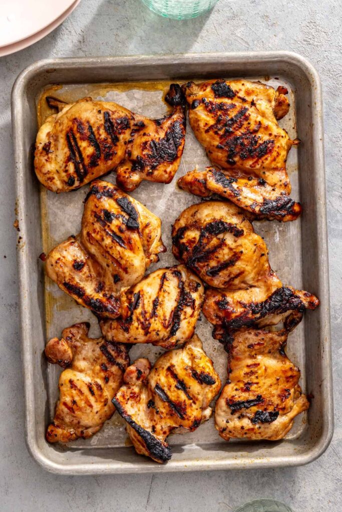 Grilled teriyaki chicken thighs resting before slicing