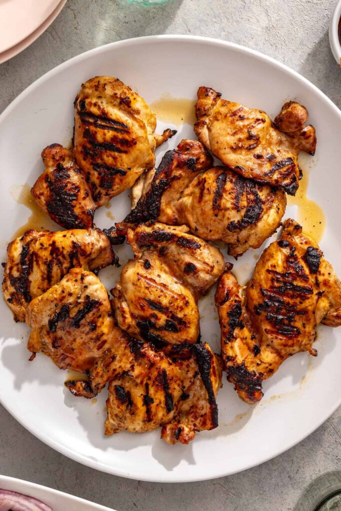 grilled teriyaki chicken thighs on a plate, ready to be served
