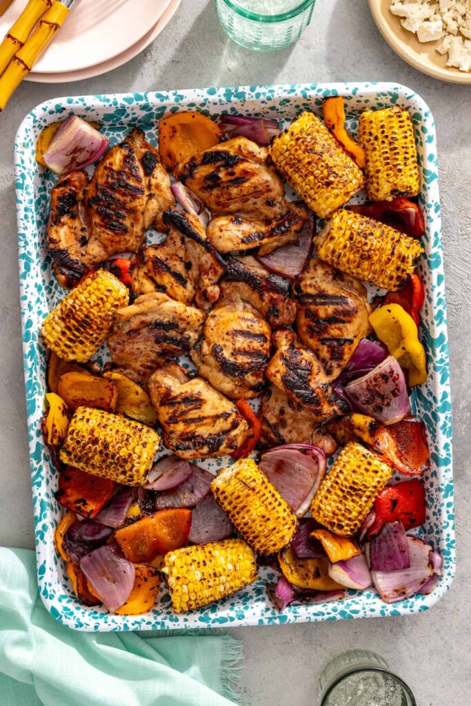 Seasoned ghee brushed over grilled corn alongside teriyaki chicken and vegetables