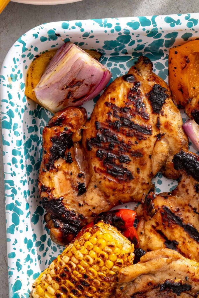 grilled teriyaki chicken with grill marks served alongside grilled vegetables