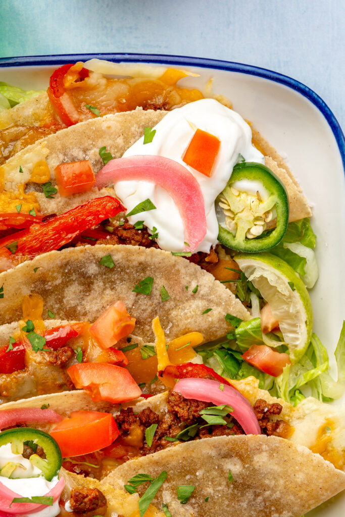 assembling oven baked tacos in baking dish
