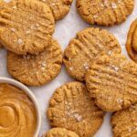 Healthy gluten-free peanut butter cookies arranged on a table with peanut butter and milk