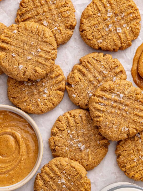 Healthy gluten-free peanut butter cookies arranged on a table with peanut butter and milk