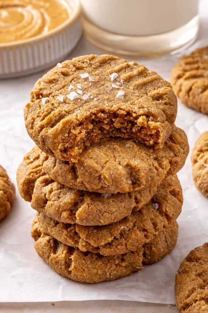 Chewy gluten-free peanut butter cookie with a bite taken out served with milk