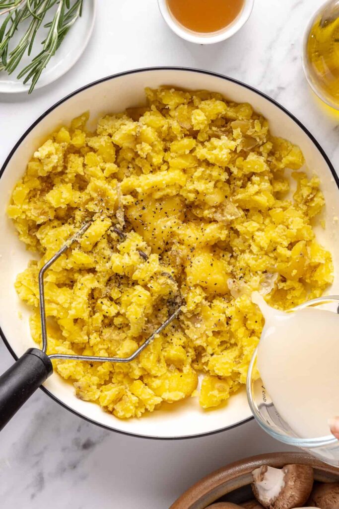 Fluffy mashed mini potatoes with ghee and almond milk, topped with fresh chives and olive oil drizzle