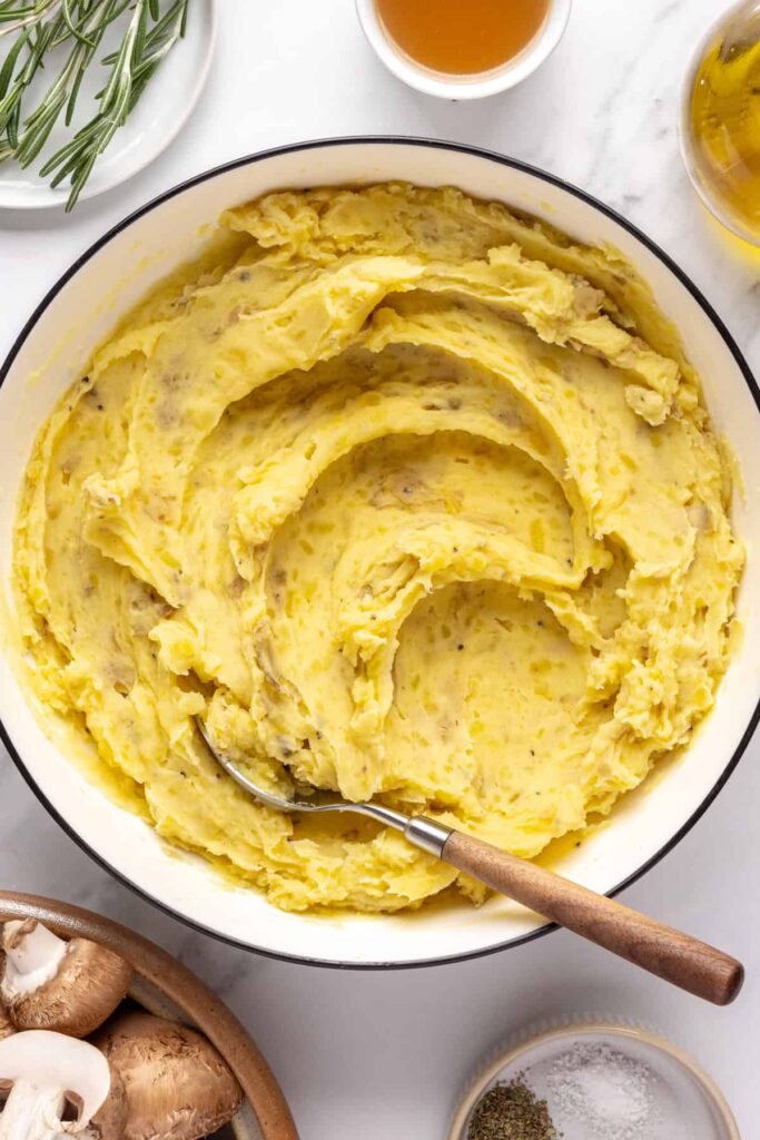 Creamy mashed mini potatoes with almond milk, ghee, and garnished with chives and olive oil