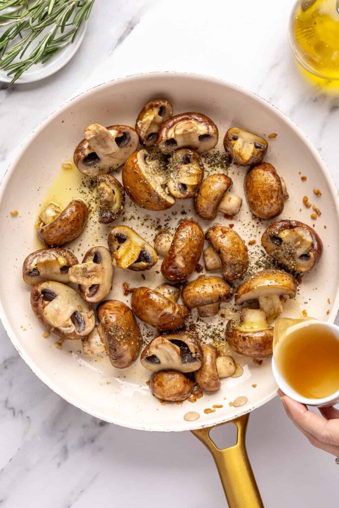 Sautéing cremini mushrooms with garlic and Italian seasoning