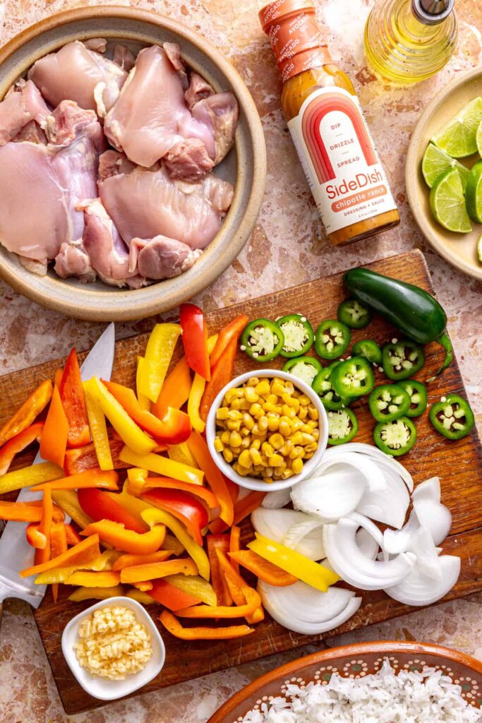 Ingredients for spicy southwest chicken skillet with chicken, peppers, corn, and chipotle ranch