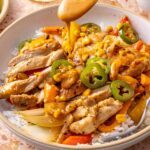 Spicy southwest chicken skillet served over rice with chipotle ranch drizzle