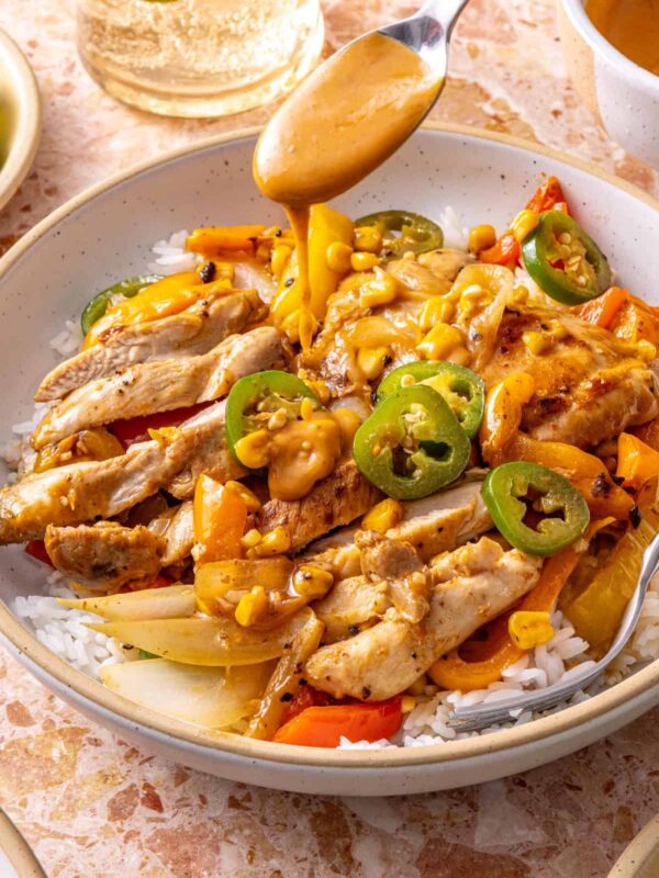 Spicy southwest chicken skillet served over rice with chipotle ranch drizzle