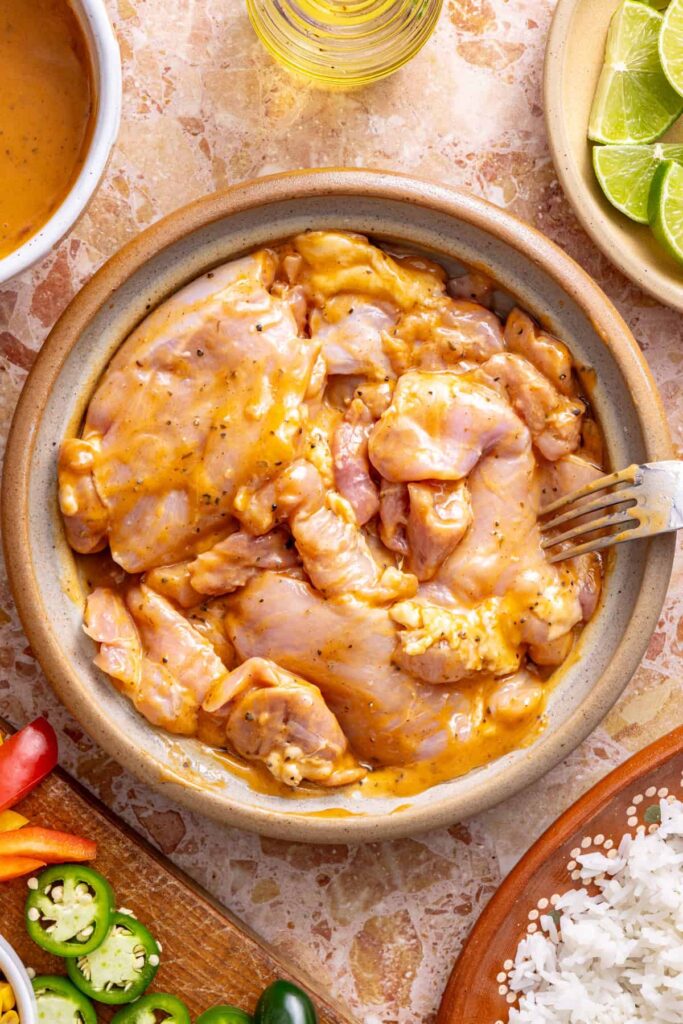 Chicken thighs marinating in chipotle ranch dressing in a bowl