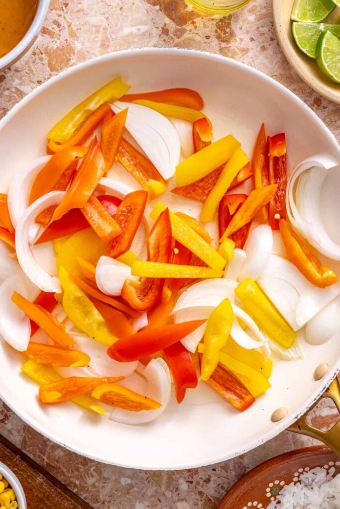 Sautéing bell peppers and onions in skillet for southwest chicken skillet