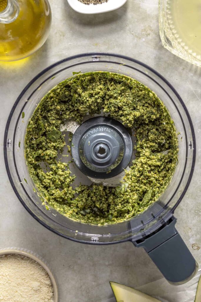 Basil pesto ingredients pulsed in food processor