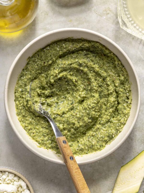 Homemade basil pesto recipe served in white bowl on styled table