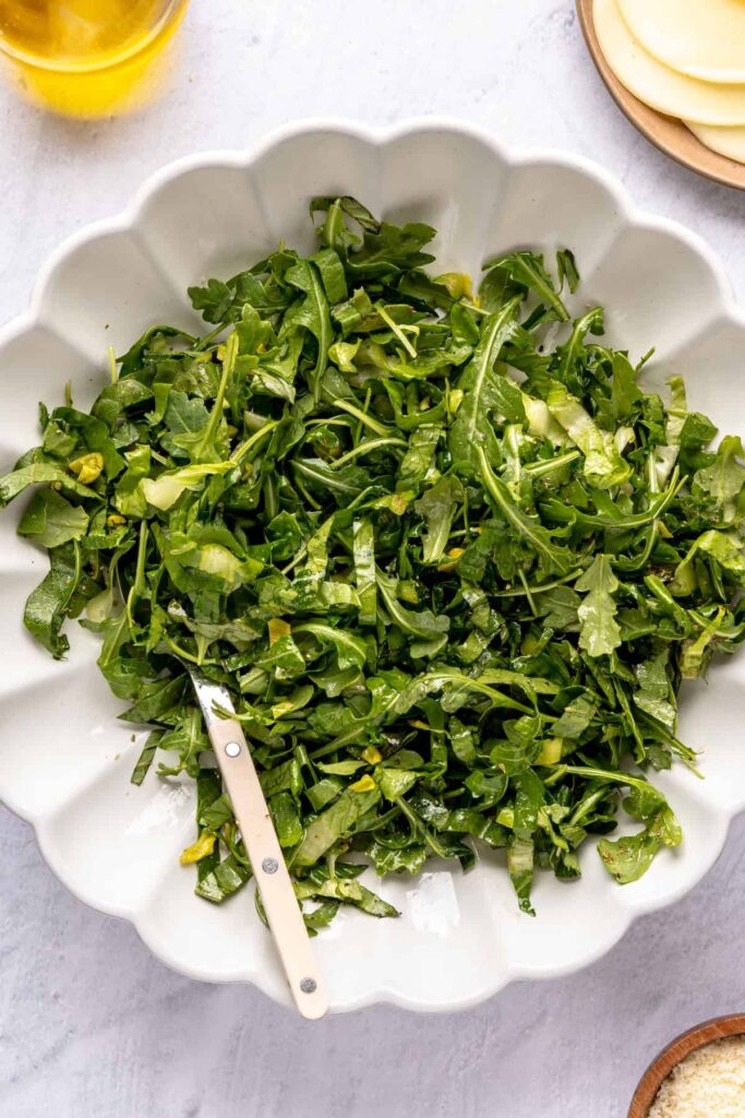 greens in a bowl for open-face chicken pesto parmesan meatball subs