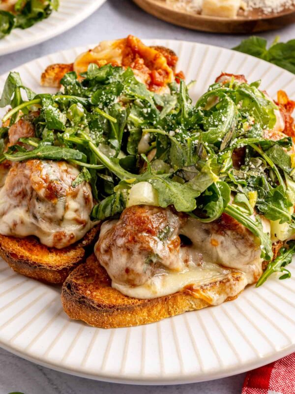 Open-faced, high-protein chicken pesto parmesan meatball subs with marinara sauce and melted cheese