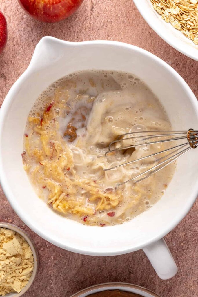 Stirring wet and dry ingredients to make high-protein baked apple oatmeal batter