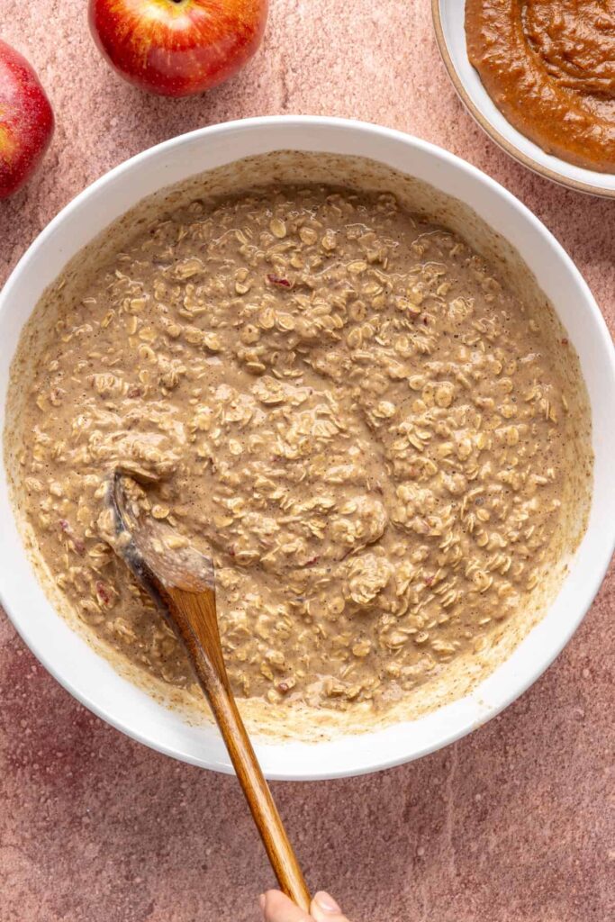 Stirring wet and dry ingredients to make high-protein baked apple oatmeal batter