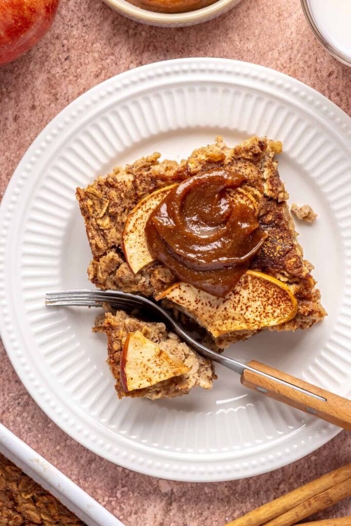 Slice of baked apple oatmeal with caramel on a white plate, cozy breakfast