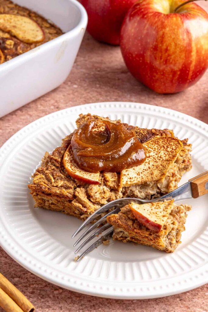 Slice of baked apple oatmeal with caramel on a white plate, cozy breakfast