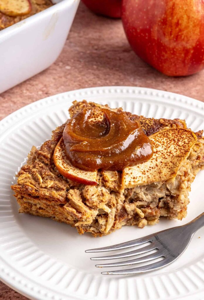 Slice of baked apple oatmeal with caramel on a white plate, cozy breakfast