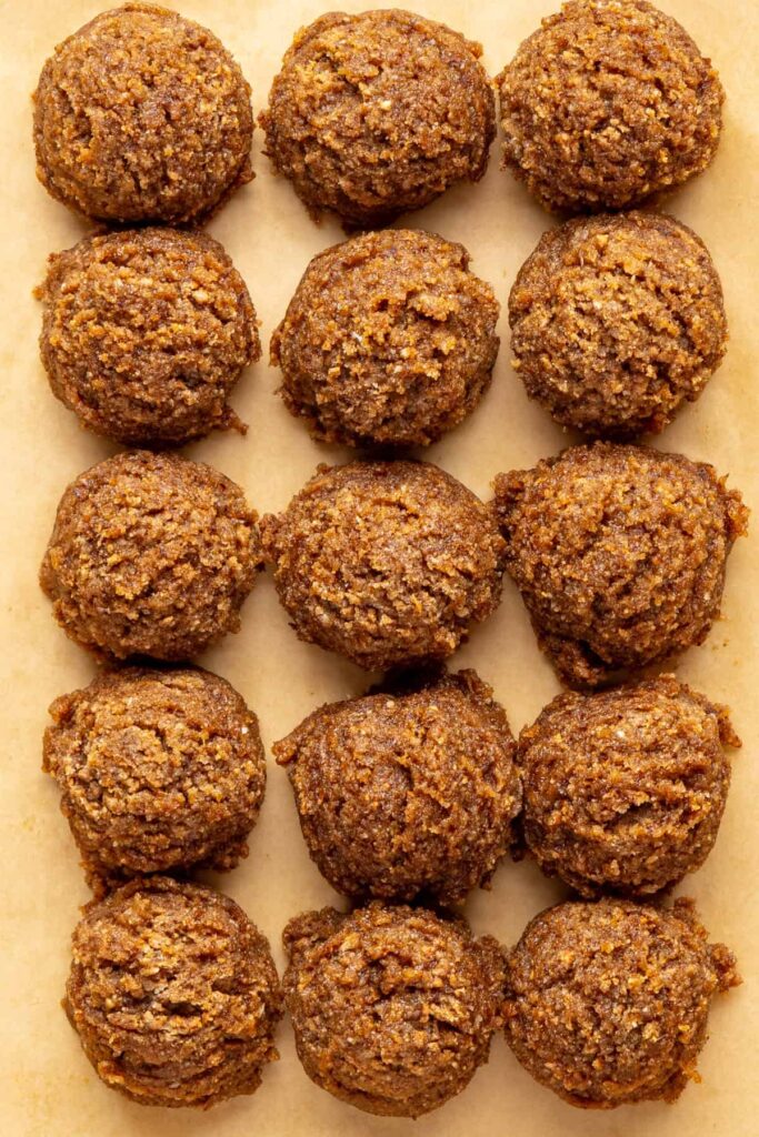 Unchilled gingerbread protein balls on parchment paper ready to set