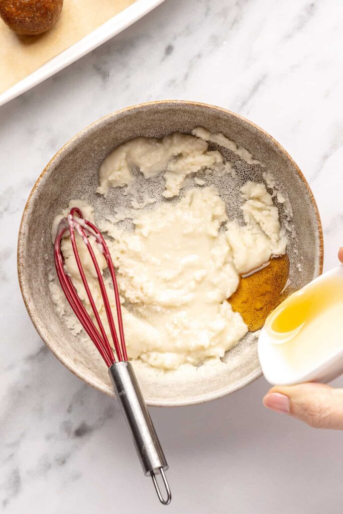 mixing melted coconut butter with maple syrup for drizzling over gingerbread protein balls