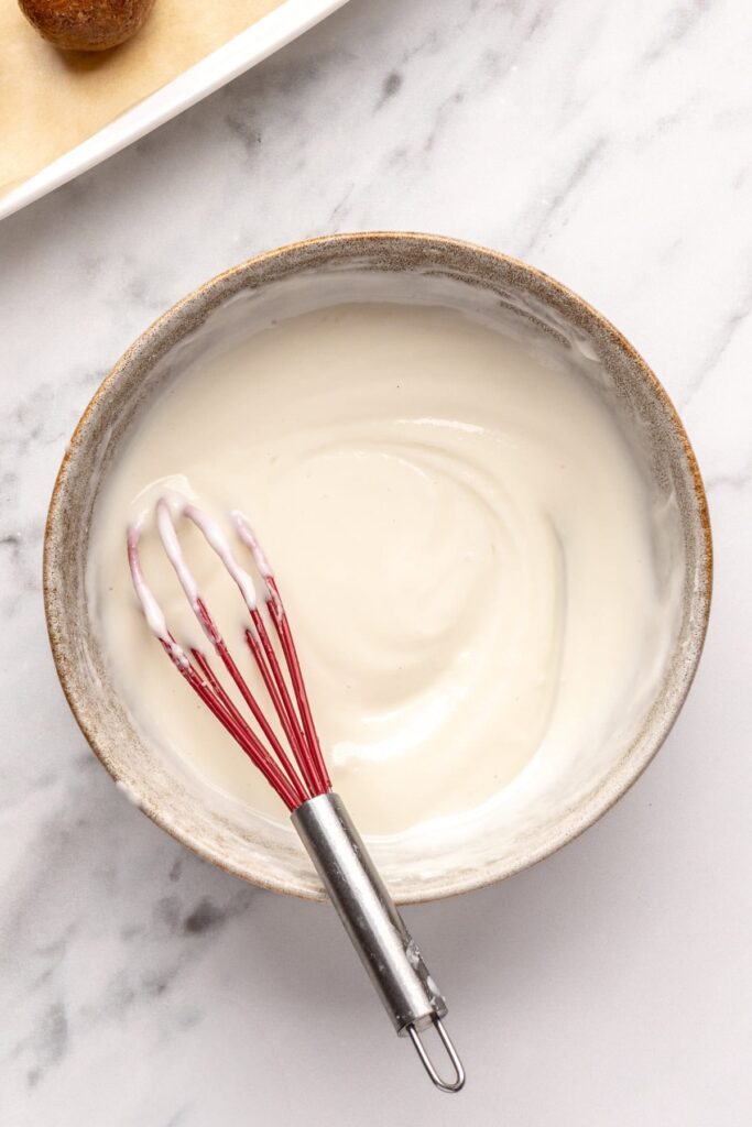Melted coconut butter with maple syrup for drizzling over gingerbread protein balls